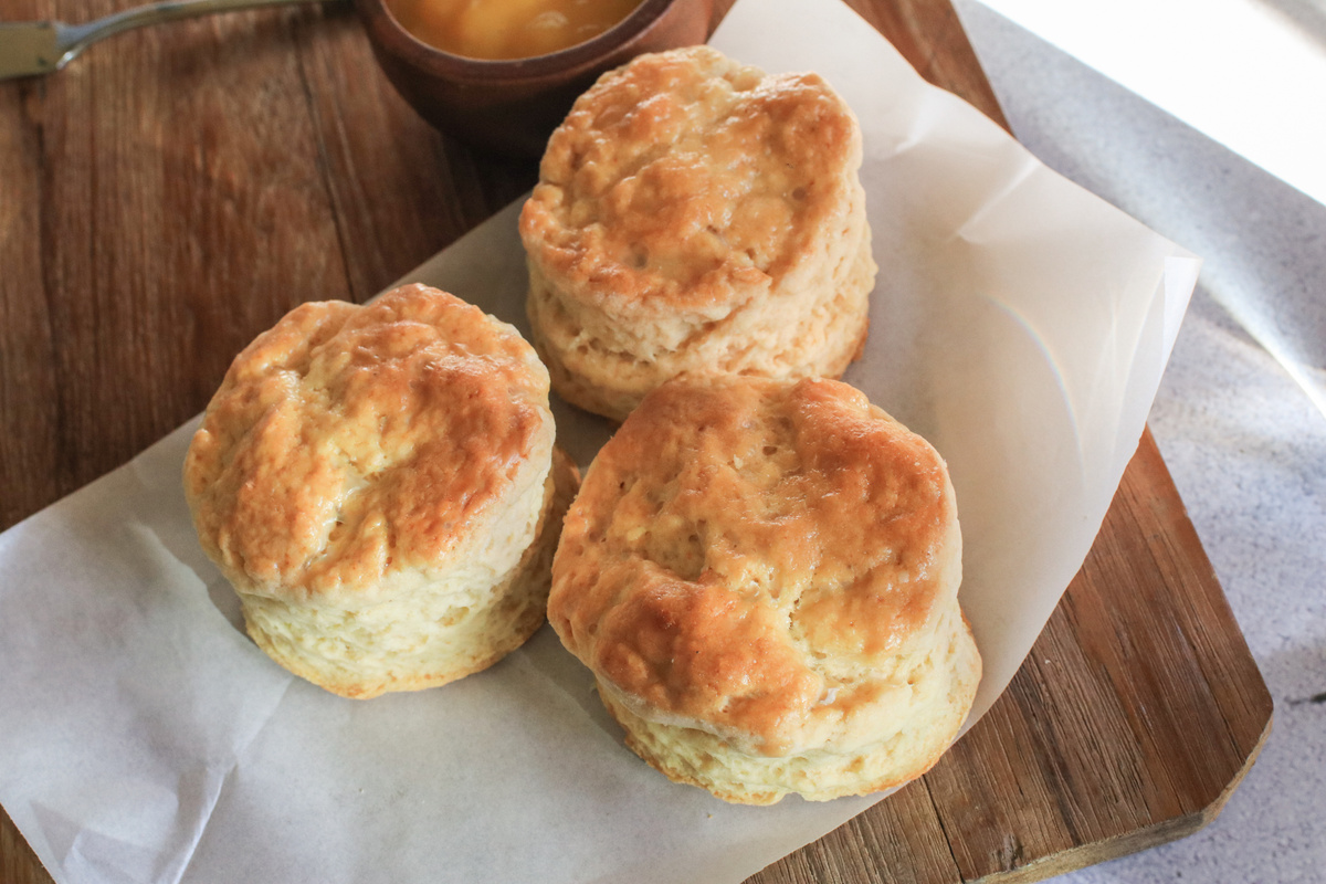 Homemade scones on wooden cutting board on white background